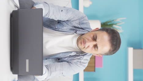 Vertical-video-of-Negative-expression-of-man-using-laptop.